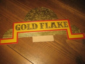Reklame  fra Norsk Engelsk Tobakksfabrik, GOLD FLAKE, fra 40 tallet. Reklama er ca 21 cm lang, og 10 cm høg, og ble brukt som reklame på krambu disken på den tid. Sjelden, vil eg tru.