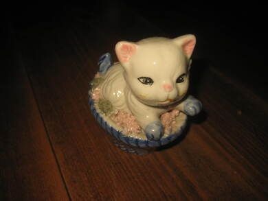 Porselens katt i kurv ca 7 cm lang kurv