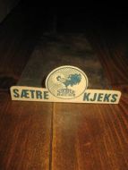 Disk reklame fra gammel landhandel metall med bakplate SÆTRE KJEKS ca 11 5 cm brei 23 cm lang