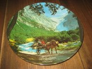 Platte i hardplast motiv fra Briksdalen Sogn 60 tallet Tillaga for oppheng på vegg Ca 19 cm i diameter