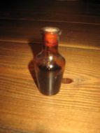Lita flaske med ubrukt innhold ca 7 cm høg