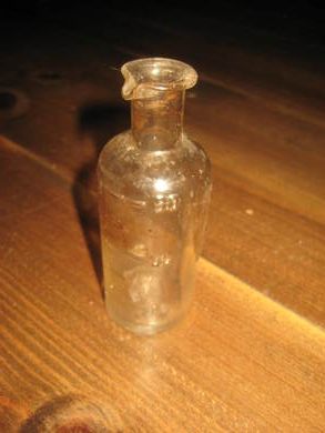Eldre flaske med helletut og merke for mål ca 9 cm høg