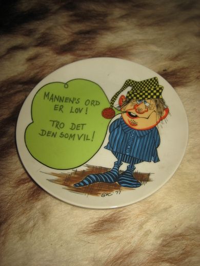 Pyntetallerken med tekst: MANNEN'S ORD ER LOV! TRO DET DEN SOM VIL!