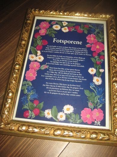 Bilde i glass og ramme med tekst: Fotsporene 4 vers