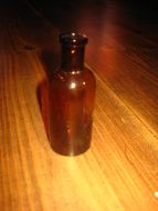 Gammel apotekerflaske ca 9 5 cm høg merka under: 40 40-50 tallet Brunt glass pen i glasset slik at sollyset skin gjennom flaska