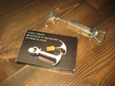 Eske med innhold, kork- og flaskeåpner i metall.