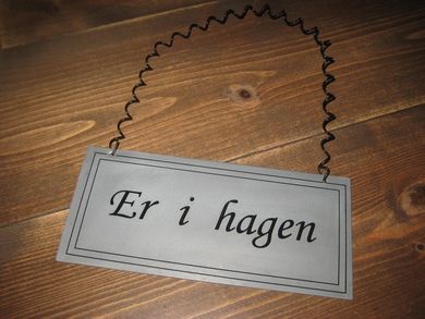 Blikkskilt med tekst: Er i hagen