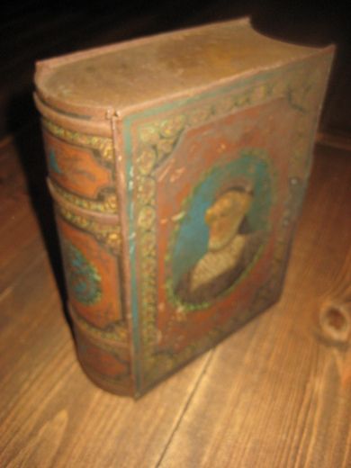 Gammel engelsk kjeksboks utforma som en bibel Med metallhempe på sida Tidleg 1900