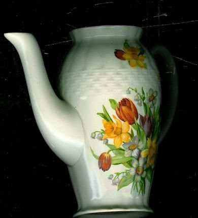 Dekorativ kanne med blomsterdekorasjon