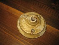 Liten takrosett i porselen, ca 8 cm i diameter, pen i taket sammen med t.d. en skomakerlampe. Må renses. 30-40 tallet.